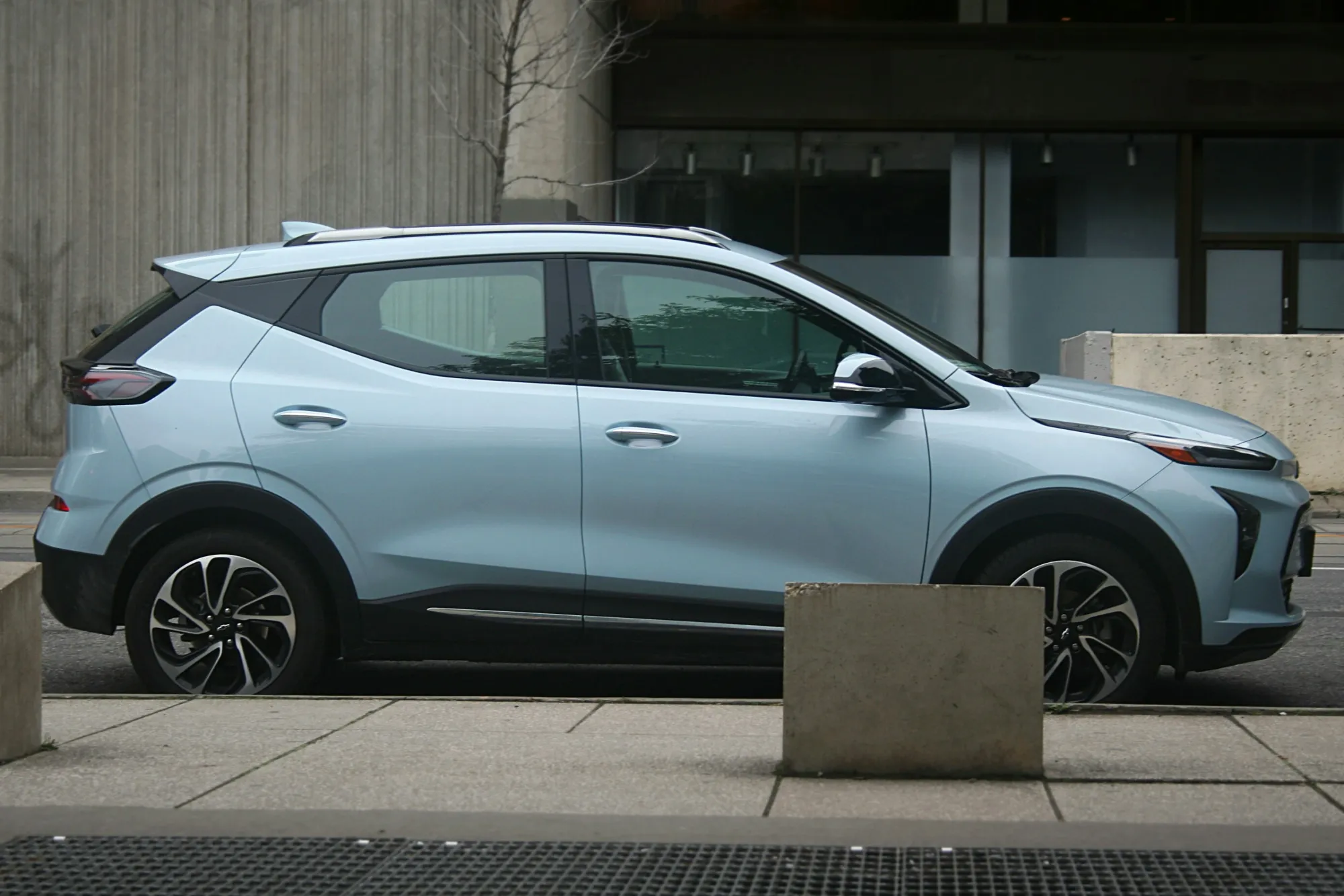 Blue Chevrolet Bolt EV parked on the side of the street.